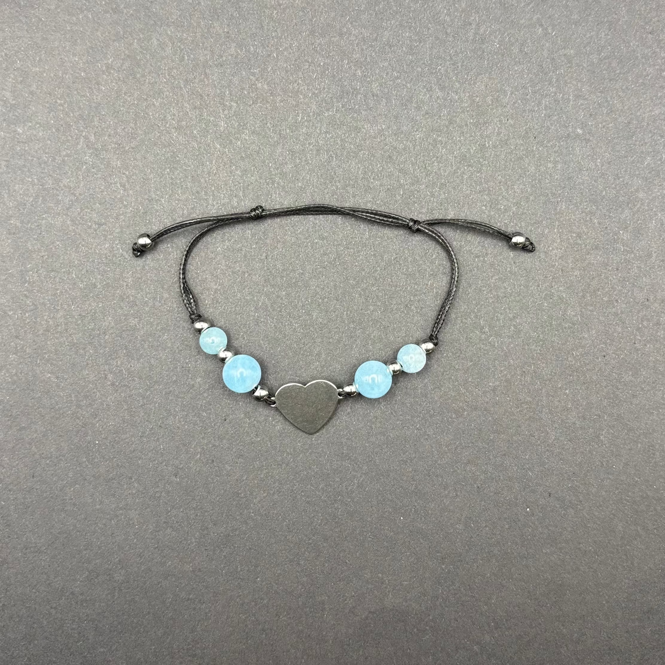 größenverstellbares Armband aus einem Herz aus Edelstahl, blauen Aquamarin Perlen und schwarzen Schnüren