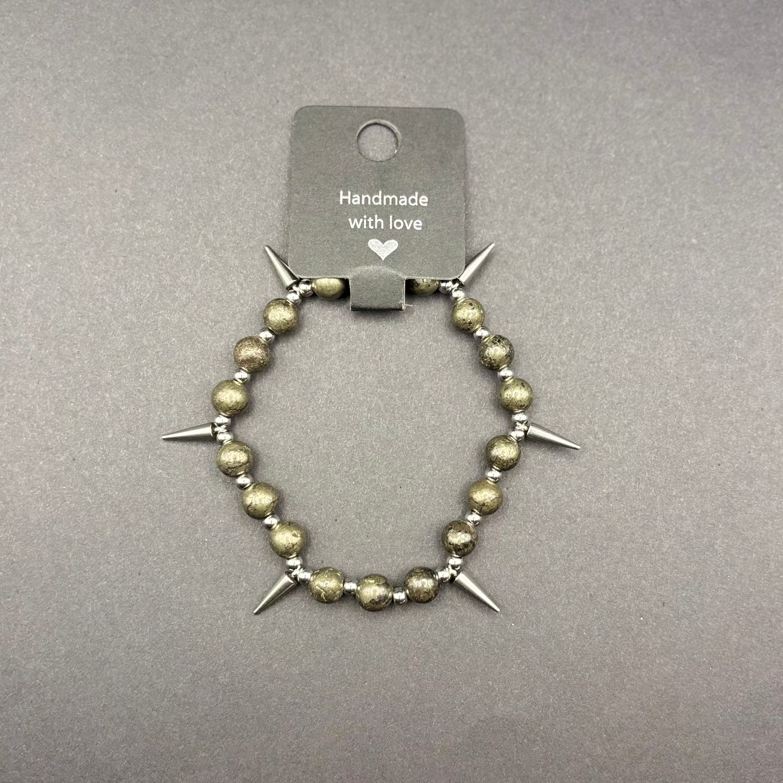 Armband aus gold schimmernden Pyrit Perle mit schwarzen Anteilen und Nieten aus Edelstahl